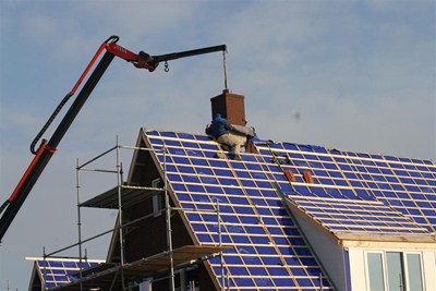 In de werkplaats is de schoorsteen gemetseld. Vervolgens kan hij op het huis gehezen worden.